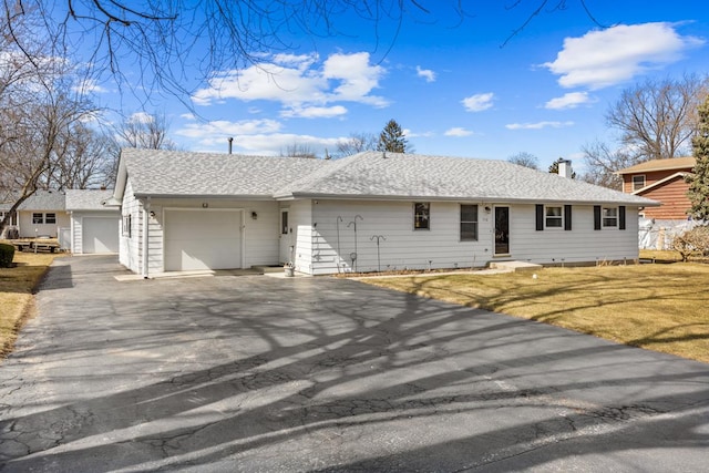 single story home featuring roof with shingles, a chimney, entry steps, a garage, and aphalt driveway