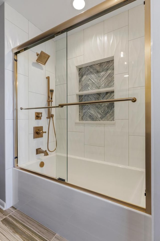 bathroom with bath / shower combo with glass door