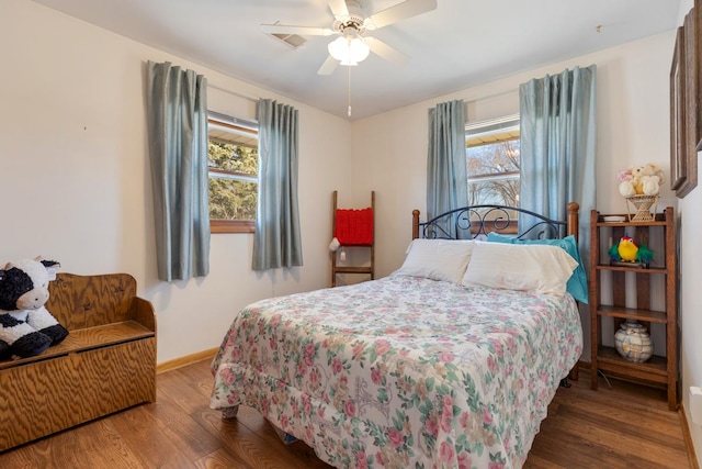 bedroom with visible vents, multiple windows, baseboards, and wood finished floors