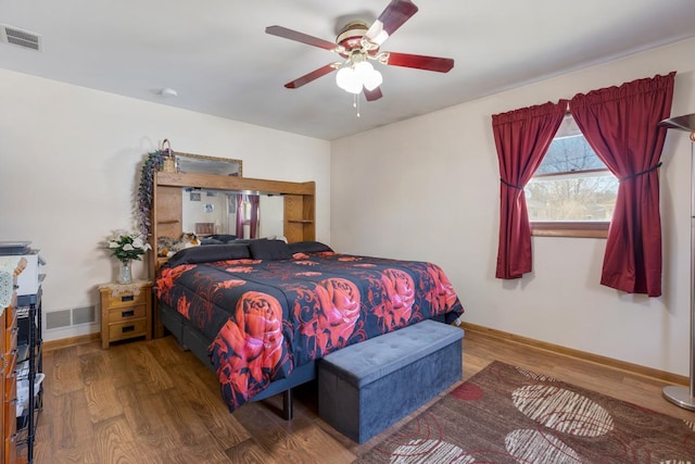 bedroom with visible vents, baseboards, and wood finished floors