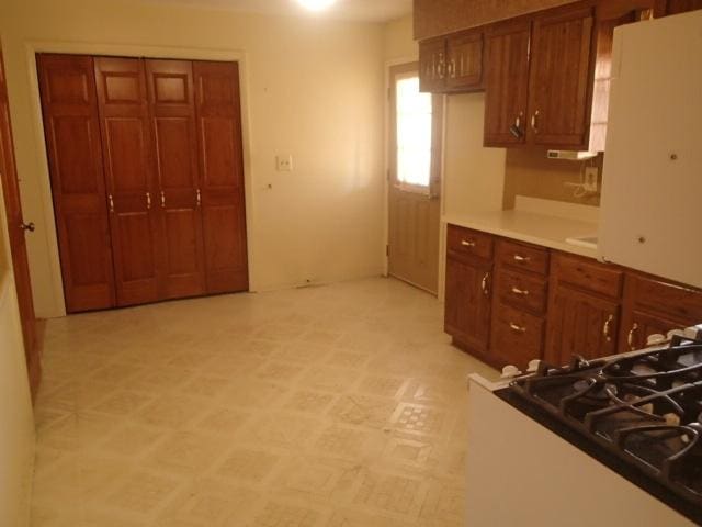 kitchen featuring light floors and brown cabinets