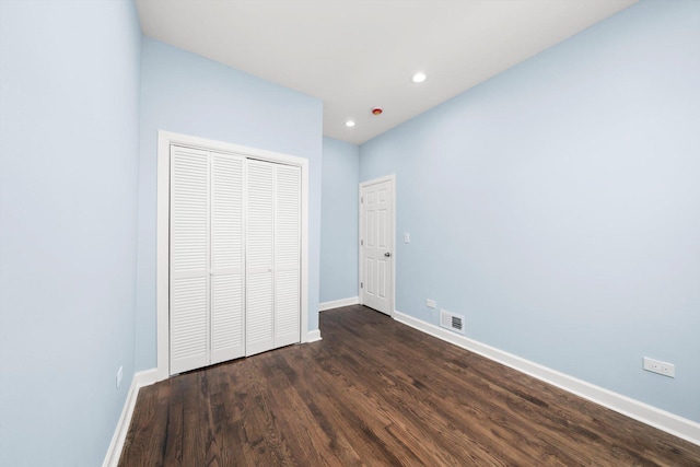unfurnished bedroom featuring baseboards, visible vents, recessed lighting, dark wood-type flooring, and a closet
