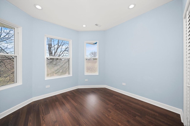 spare room with recessed lighting, dark wood-type flooring, and baseboards