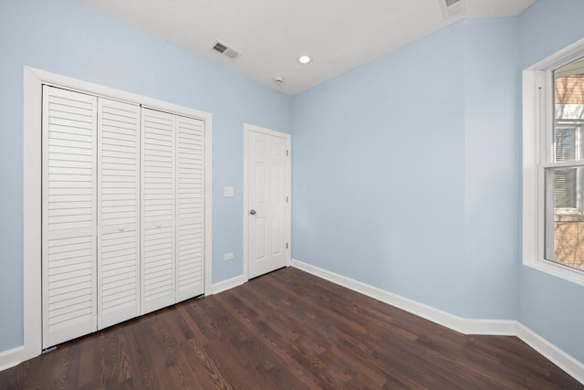 unfurnished bedroom featuring dark wood finished floors, visible vents, and baseboards