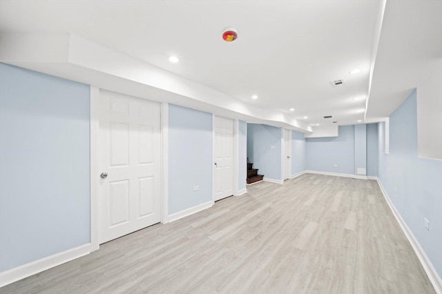 finished below grade area with visible vents, baseboards, stairway, light wood-type flooring, and recessed lighting