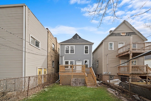back of property with a fenced backyard, a lawn, and a deck