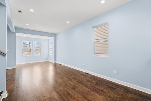 unfurnished living room with recessed lighting, visible vents, baseboards, and dark wood-style flooring