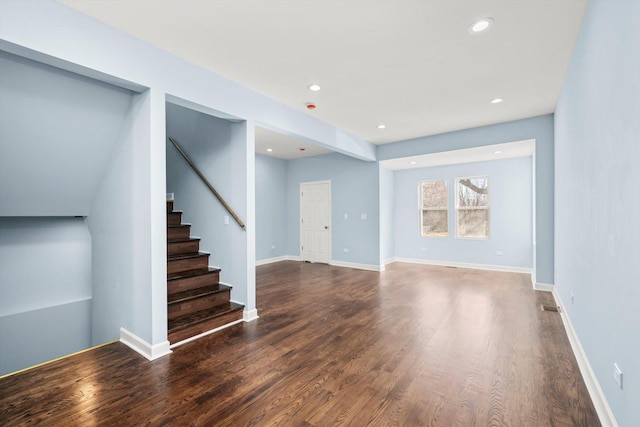 unfurnished living room featuring visible vents, wood finished floors, recessed lighting, baseboards, and stairs