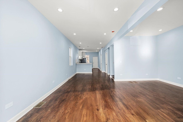 unfurnished living room with dark wood-type flooring, recessed lighting, and visible vents