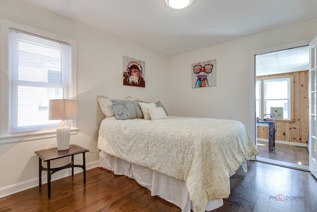 bedroom with baseboards and dark wood-style flooring