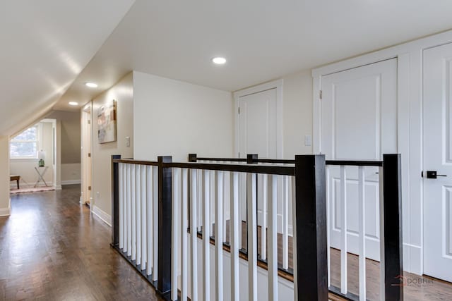 hall featuring an upstairs landing, recessed lighting, baseboards, dark wood-style flooring, and vaulted ceiling