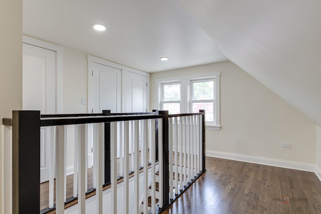 hall with baseboards, vaulted ceiling, an upstairs landing, recessed lighting, and dark wood-style flooring