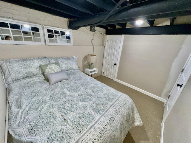 bedroom featuring finished concrete flooring and baseboards