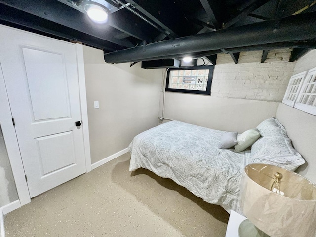 bedroom with baseboards and finished concrete flooring