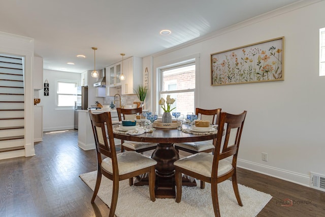 dining room with visible vents, dark wood-type flooring, stairway, crown molding, and baseboards