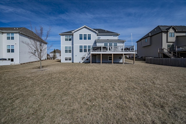 rear view of property with a wooden deck, a lawn, and stairs