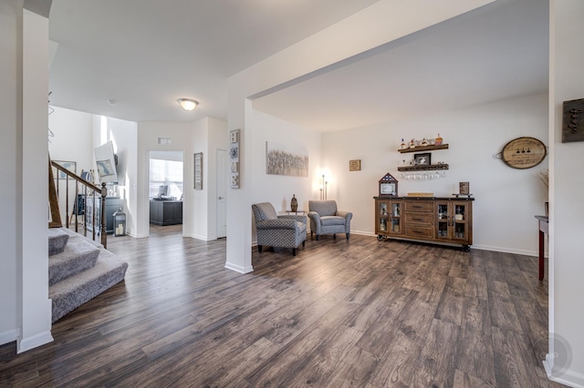 living room with dark wood finished floors, stairs, and baseboards