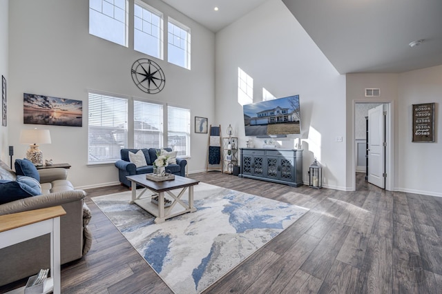 living room featuring a healthy amount of sunlight, baseboards, and wood finished floors