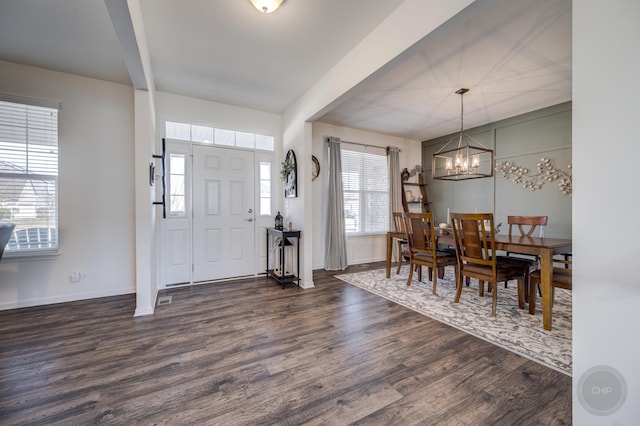 entryway featuring a notable chandelier, dark wood-type flooring, and baseboards