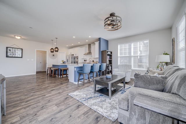 living room with recessed lighting, a chandelier, baseboards, and wood finished floors