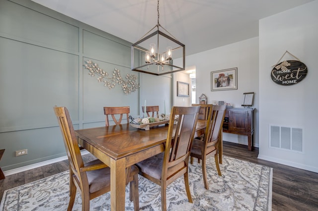 dining space featuring a notable chandelier, visible vents, baseboards, and wood finished floors