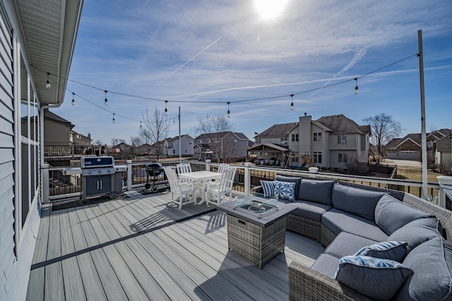 wooden terrace with an outdoor living space with a fire pit, outdoor dining area, and a residential view