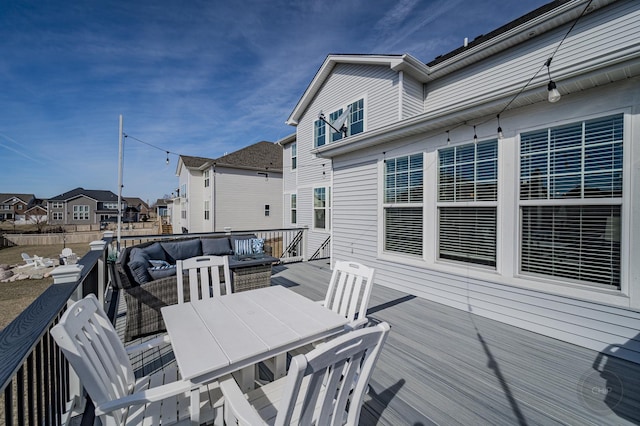 deck featuring outdoor dining area, a residential view, and an outdoor hangout area