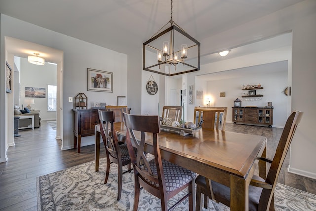 dining space with a notable chandelier, baseboards, and dark wood-style flooring