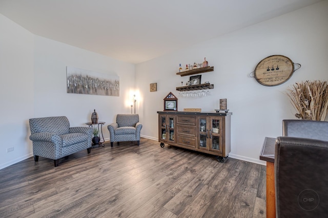 living area with baseboards, wood finished floors, and a dry bar