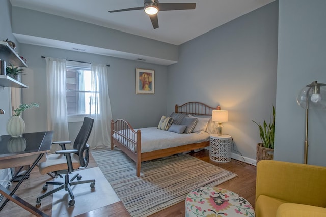 bedroom featuring visible vents, ceiling fan, baseboards, and wood finished floors