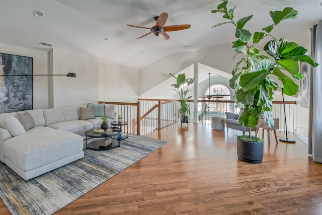 living area featuring visible vents, ceiling fan, lofted ceiling, and wood finished floors