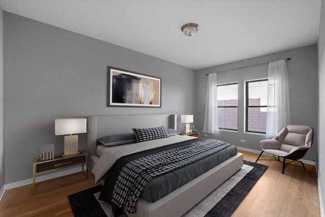 bedroom with baseboards and wood finished floors