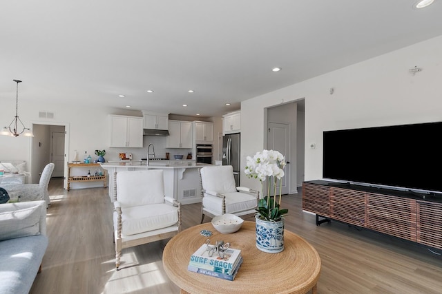 living area featuring recessed lighting, visible vents, and light wood-style flooring