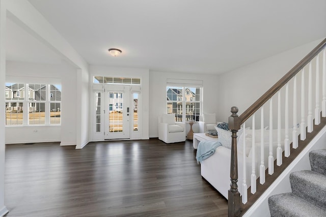 living room featuring dark wood finished floors, stairs, and baseboards