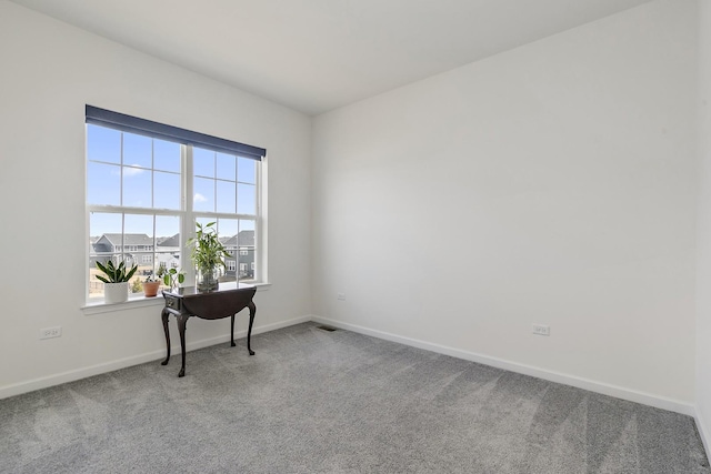 carpeted office featuring visible vents and baseboards