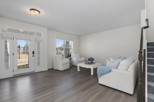 living area with stairway, wood finished floors, and a healthy amount of sunlight