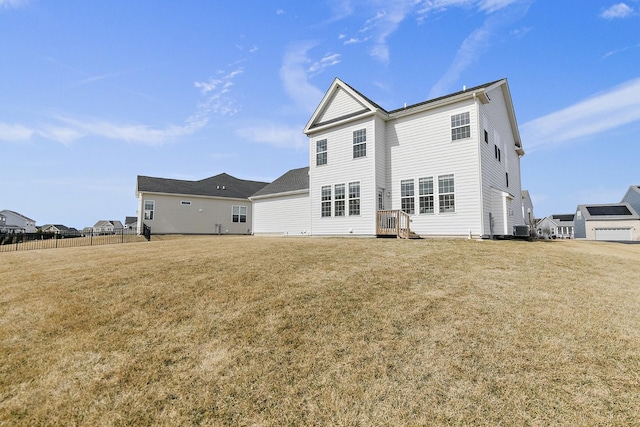 back of property featuring a yard, central AC unit, and fence