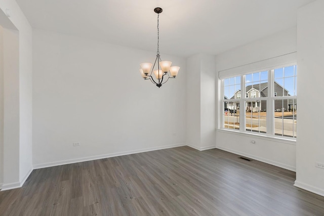 unfurnished dining area featuring an inviting chandelier, dark wood-style floors, visible vents, and baseboards