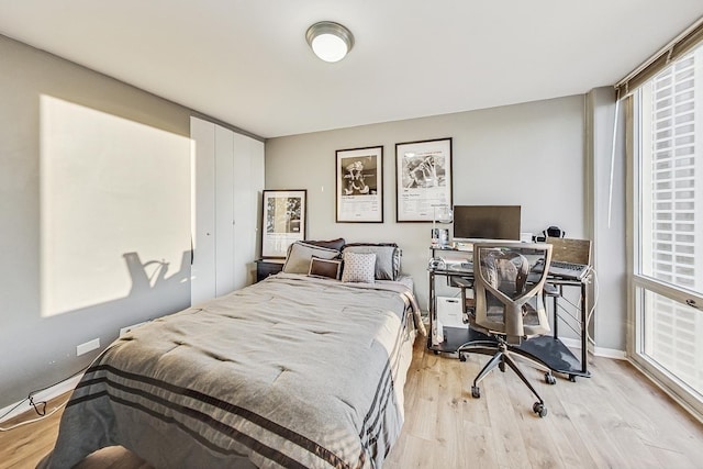 bedroom featuring light wood-style flooring and baseboards