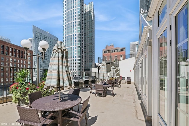 view of patio with a city view, a grill, and outdoor dining area