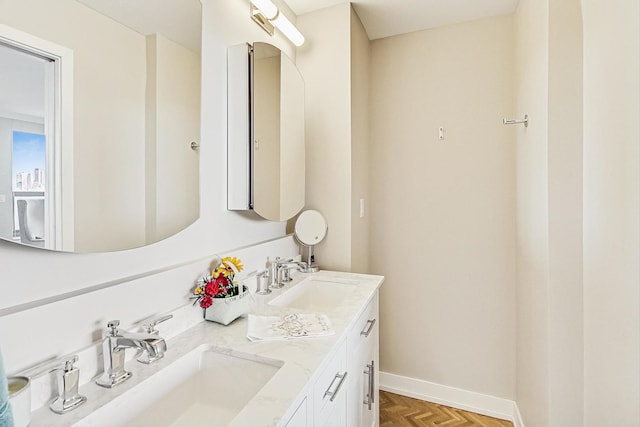 full bathroom with a sink, baseboards, and double vanity