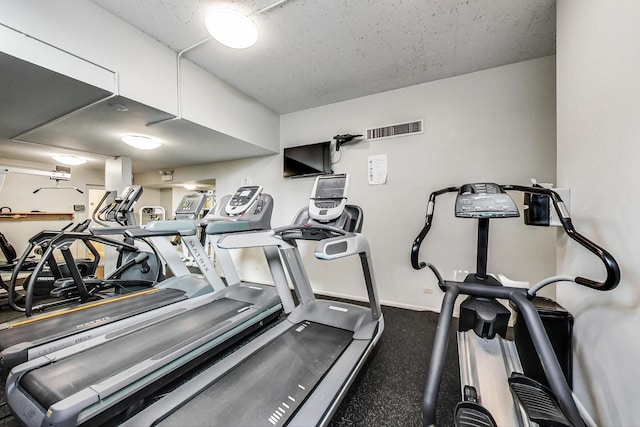 gym featuring baseboards and visible vents