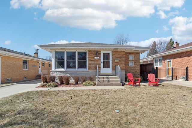 view of front facade featuring a front yard, fence, and brick siding