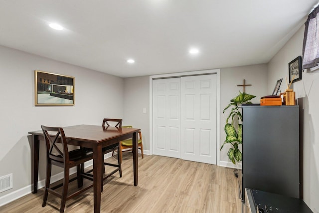 dining space with light wood-type flooring and baseboards