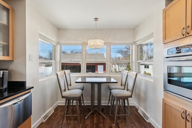 dining room featuring visible vents, dark wood-type flooring, and baseboards