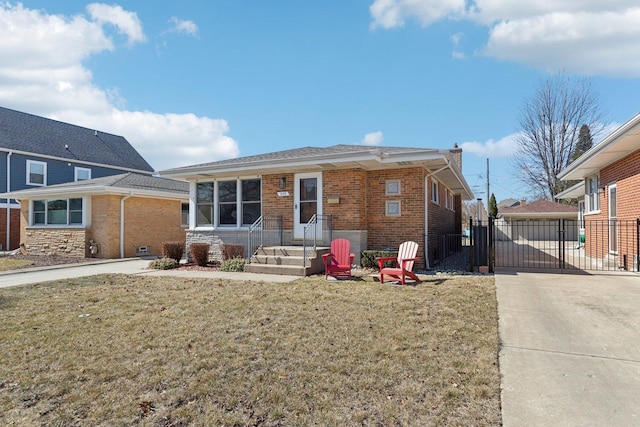 view of front of house featuring a gate, brick siding, a front lawn, and fence