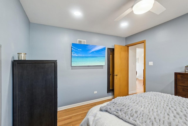 bedroom featuring ceiling fan, visible vents, baseboards, and wood finished floors