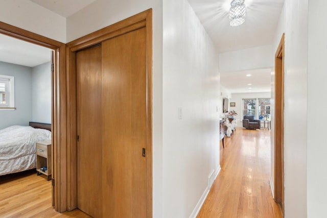 hallway with light wood-style flooring and baseboards