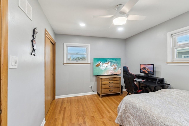 bedroom featuring light wood finished floors, visible vents, ceiling fan, baseboards, and a closet