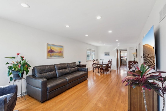 living area with recessed lighting, visible vents, baseboards, and light wood-style flooring